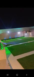 ein Baseballfeld in der Nacht mit grünem Gras und Licht in der Unterkunft شالية مون لايت in Umm Lajj