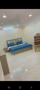 Un dormitorio con una cama con almohadas azules. en شالية مون لايت, en Umm Lajj