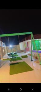 eine Schaukel mit einem Licht auf dem Spielplatz in der Unterkunft شالية مون لايت in Umm Lajj
