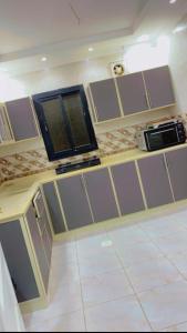 cocina con armarios grises y microondas en شالية مون لايت, en Umm Lajj
