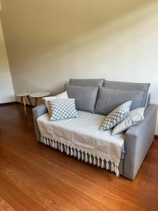 a couch in a living room with pillows on it at Apartamento Centro ao lado do Country Club in Nova Friburgo