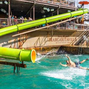 a man swimming in the water on a water slide at Andeve's tranquil beautiful home in Montego Bay