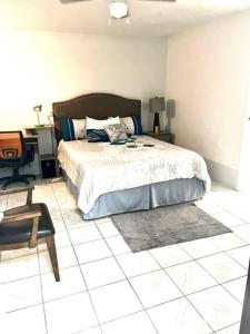 a bedroom with a bed and a desk and a chair at Andeve's tranquil beautiful home in Montego Bay