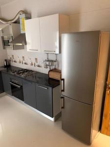 una cucina con frigorifero in acciaio inossidabile e armadietti bianchi di Good Time Guaranteed •7 a Dakar