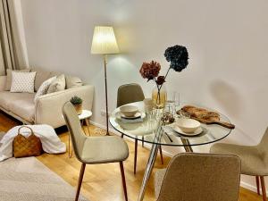 a living room with a glass table and chairs at Zentrales Apartment mit Balkon in Vienna