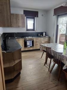 a kitchen with a table and a table and chairs at Falcade Dolomiti La Quiete piano terra in Fregona