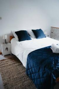 - une chambre avec un grand lit et des oreillers bleus dans l'établissement Moulin MORIN, à Vaucelles