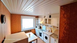 eine Küche mit weißen Schränken und einem Fenster in der Unterkunft Apartment Ramune in Šiauliai