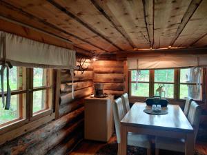 a dining room with a table and chairs and windows at Kivakko Saariselän paratiisi - Oma ranta & sauna in Saariselka