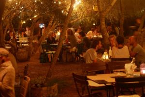 un gruppo di persone seduti ai tavoli in un ristorante di notte di Domaine Panciarella a Saint-Florent