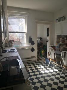 a kitchen with a checkered floor and a table and chairs at Midtown Toronto Next to Subway Line 1 in Toronto