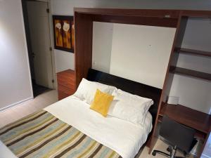 a bedroom with a bed with a yellow pillow at Apart hotel Fraga in Santiago