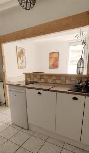 a kitchen with white cabinets and a counter top at Le Lamourguier in Narbonne