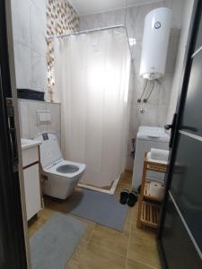 een witte badkamer met een toilet en een douche bij Apartmani Park in Novi Pazar