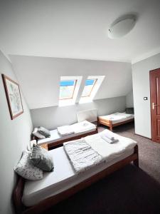Zimmer mit 2 Betten und 2 Fenstern in der Unterkunft Pensjonat Rondo in Września