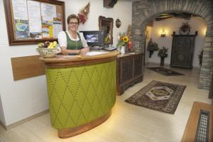 a woman is standing at a counter in a room at Hotel Stegmühlhof in Mauterndorf