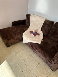 a brown couch with a plate on top of it at Apartamento de 2 habitaciones Sant Andreu in Barcelona