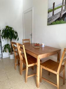 a wooden table and chairs with a bowl of fruit on it at Apartamento de 2 habitaciones Sant Andreu in Barcelona