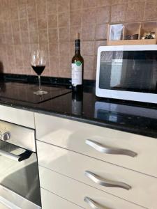 a bottle of wine and a wine glass on a counter at Apartamento de 2 habitaciones Sant Andreu in Barcelona