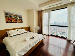 een slaapkamer met een groot bed en een groot raam bij Vinhomes Royal City#3BR Serviced Apartment in Hanoi