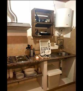 eine Küche mit einer Theke mit einer Spüle und einer Mikrowelle in der Unterkunft House on the Beach in Apúlia