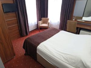 a hotel room with a bed and a desk and window at Pirotel Hotel in Konya