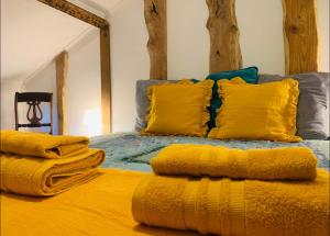 a bed with yellow pillows and blankets on it at House on the Beach in Apúlia