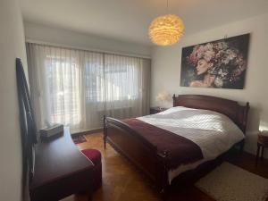 een slaapkamer met een bed en een groot raam bij Appartement Axelle in Blankenberge