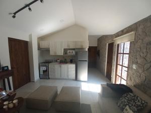 a kitchen with white cabinets and a couch in a room at Maria Blanca in Santeagueda