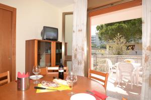 a dining room table with a view of a balcony at Orchidea in Bibione