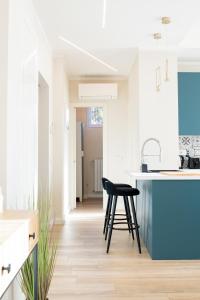 a kitchen with a black stool and a blue island at Blu Iris - Deluxe apartment with jacuzzi in Lesa