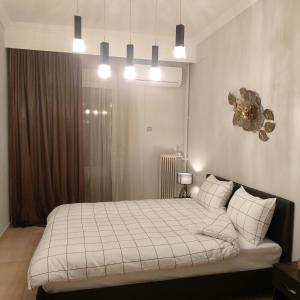 a bedroom with a bed with white sheets and a window at Vaggoula's Luxury Apartment 1 in Serres