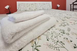 a pile of white towels sitting on top of a bed at La casa di Giada in Calatabiano