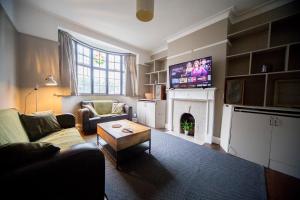 a living room with a couch and a fireplace with a tv at Fabulous Camberwell Home Z2 in London