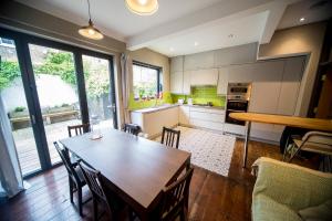 cocina y comedor con mesa de madera en Fabulous Camberwell Home Z2, en Londres