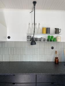 a kitchen with a black counter top and white tiles at Tomannsbolig på Rosenborg in Trondheim