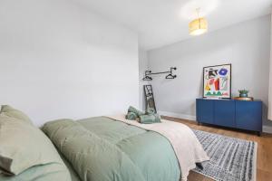 1 dormitorio con cama verde y armario azul en Modern 2 Bedroom Townhouse Flat in King’s Cross, en Londres