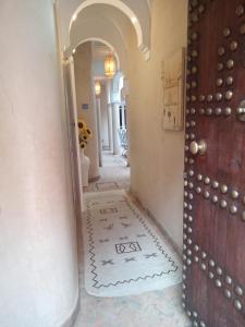 a hallway with a door and a floor with a welcome mat at RIAD AWINATI Location Privatisée ,piscine chauffée in Marrakesh