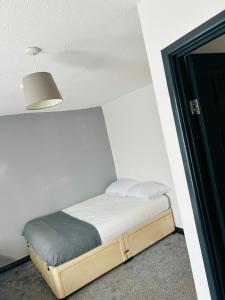 Cama pequeña en habitación con lámpara en BG Homes, en Peterborough