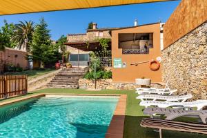uma piscina com cadeiras e uma casa em Can Nentia em Fonteta