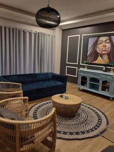 Lira Boutique Lodge في ثوهوياندو: غرفة معيشة مع أريكة زرقاء وطاولة