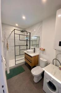 uma casa de banho com um WC, um lavatório e um espelho. em Appartement proche plage et commerces em Royan