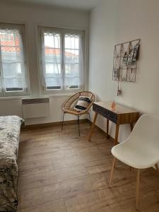 a room with a desk and a chair and a table at Appartement proche plage et commerces in Royan