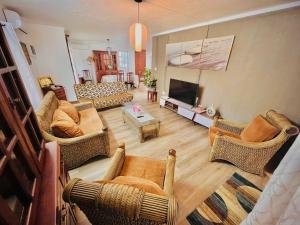 a living room with a couch and chairs and a television at N.Caunhye Villa in Pereybere