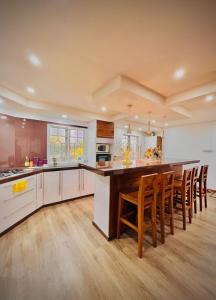 a large kitchen with a large island with wooden chairs at N.Caunhye Villa in Pereybere