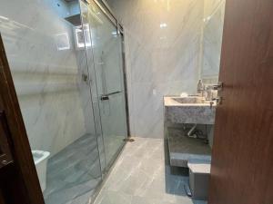 a bathroom with a glass shower and a sink at Villa Ajaman in Ajman 