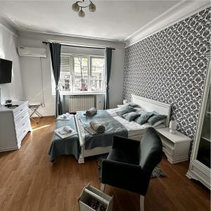 een slaapkamer met een bed en een stoel erin bij Bloom apartments in Belgrado