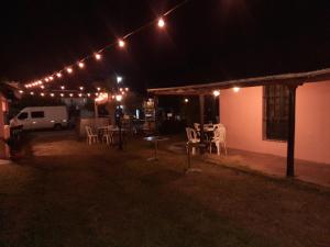 eine Terrasse mit einem Tisch und Stühlen in der Nacht in der Unterkunft Hotel Octavio in Itatí