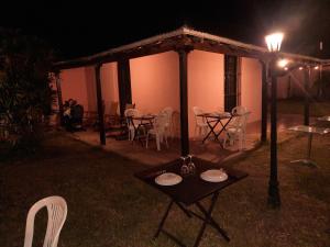 - une table et des chaises devant une maison la nuit dans l'établissement Hotel Octavio, à Itatí