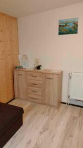 ein Zimmer mit einer hölzernen Kommode in einem Zimmer in der Unterkunft Oleandria-,, Domek Poziomeczka" nr 33 -ogrzewany w okresie jesienno-zimowym in Biskupiec + 13 Fotos
